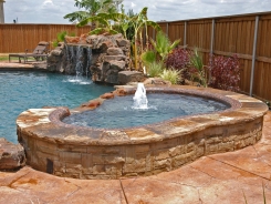 Stone Grotto and Raised Spa with Pebble Sheen in Prosper