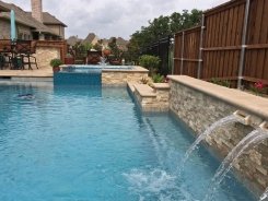 Iridescent Glass Tile Spa, Aqua Blue Pebble Sheen and Stone Scuppers in Frisco
