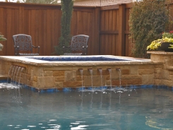 Iridescent Glass Tile Spa, Brass Spillways with Ocean Blue Pebble Sheen in Allen