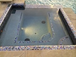 Iridescent Glass Tile Spa with Trim Tile and Aqua Blue Pebble Sheen in Frisco (1)