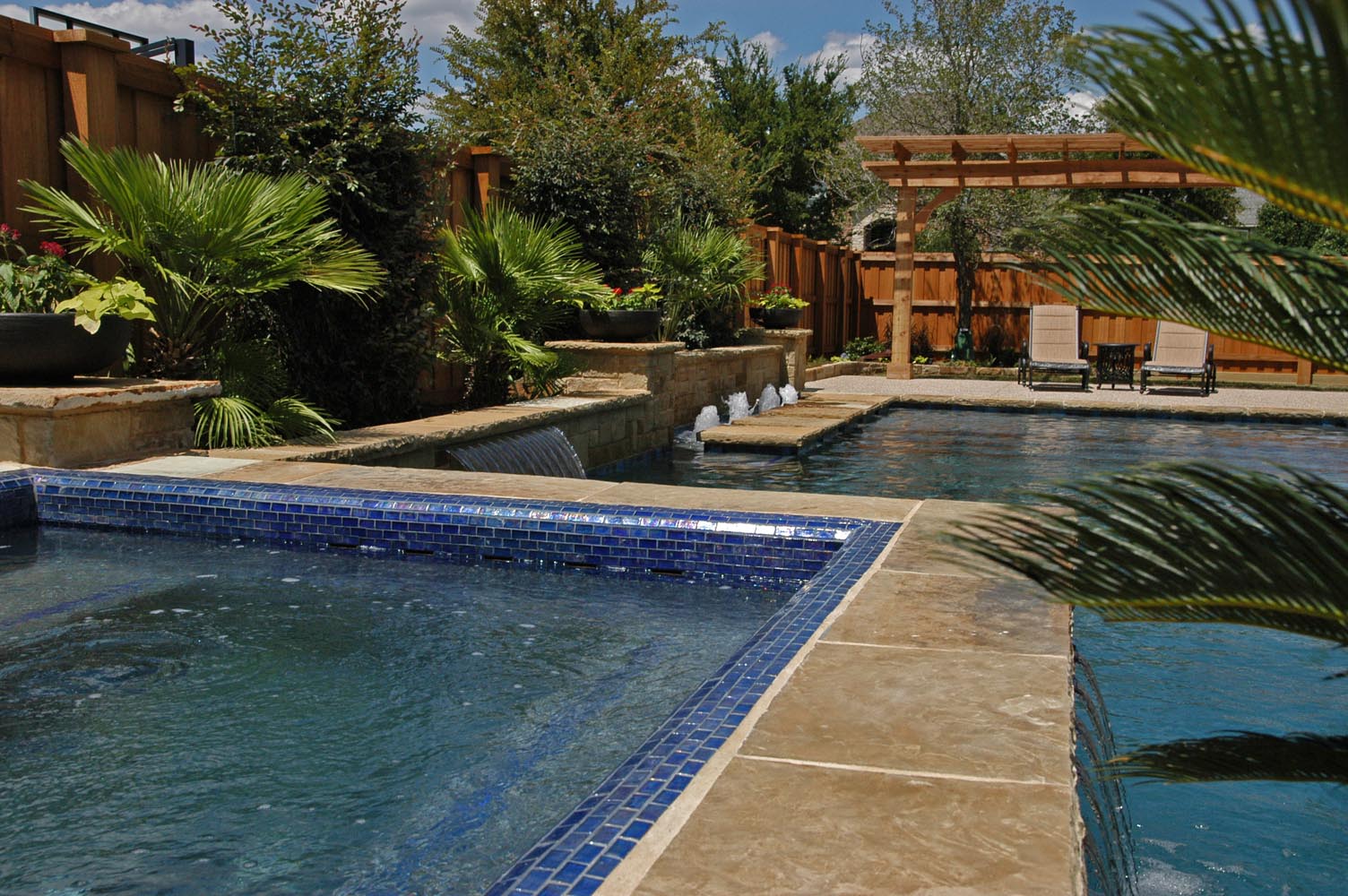 Iridescent Glass Tile Spa with Ocean Blue Pebble Sheen and Bubblers in Allen