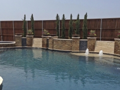 Free Form Pool, Bubblers, Sheer Descents Ocean Blue Pebble Sheen with Stone Walls and Columns in Frisco