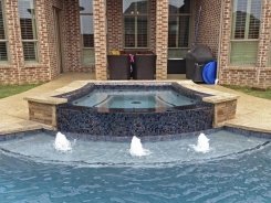 Iridescent Glass Tile Spa with Aqua Blue Pebble Sheen and Bubblers in Prosper